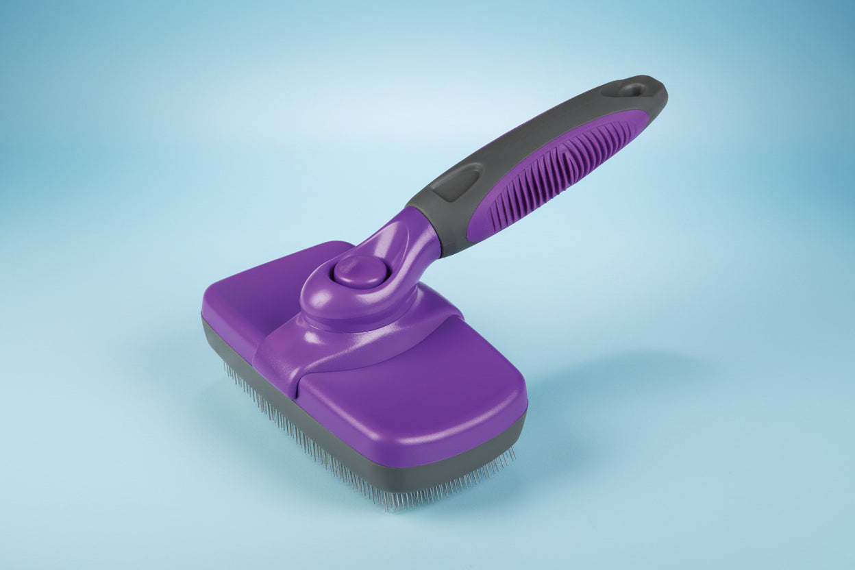 Purple pet grooming brush with black handle on a white background
