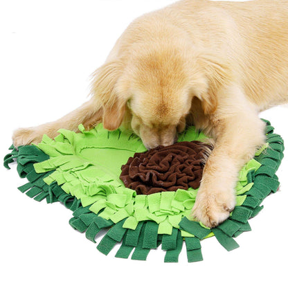 Dog playing with a green and brown snuffle mat on a white background