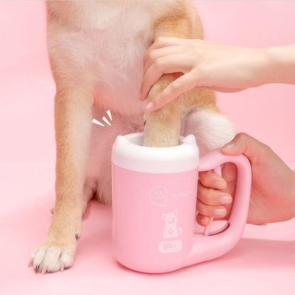 Person holding a pink mug with a dog's paw inside on a pink background