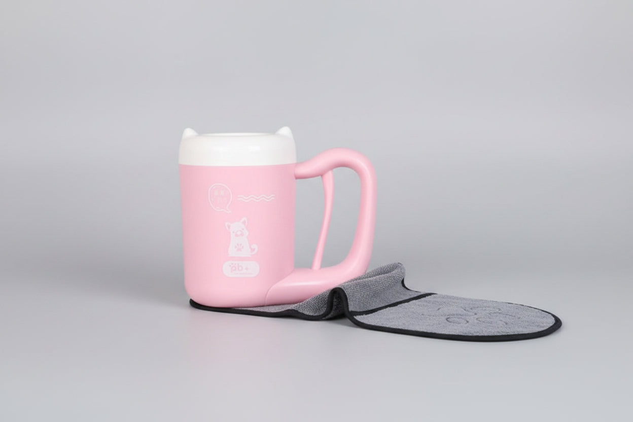 Pink mug with a gray bat-shaped towel hanging on a pegboard.