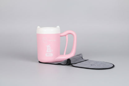 Pink mug with a gray bat-shaped towel hanging on a pegboard.