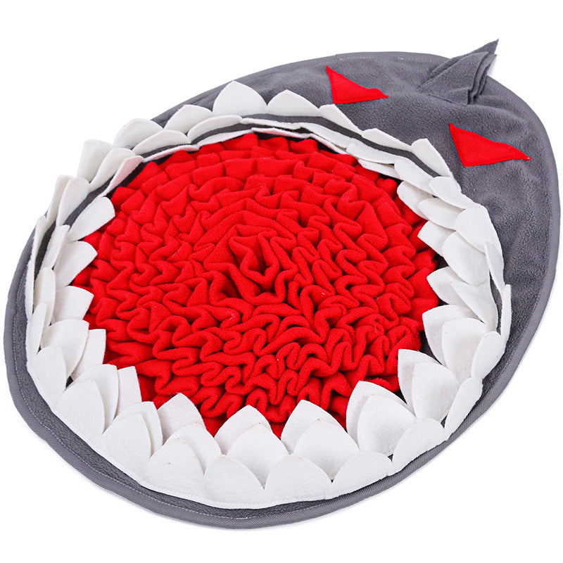 Shark-shaped pet toy with red interior, white spikes, and gray exterior on a white background