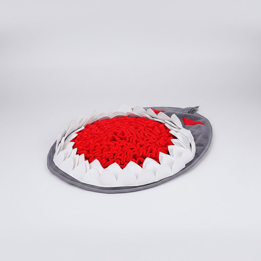 Shark-shaped pet toy with red interior, white spikes, and gray exterior