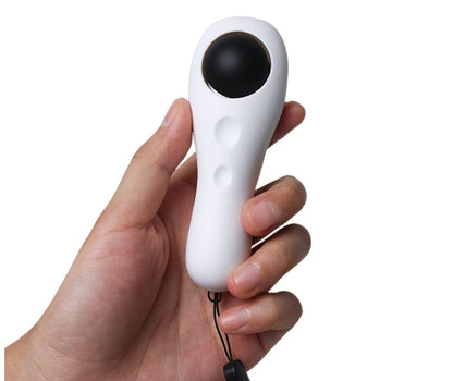 Hand holding a white handheld device with a black sphere on a white background